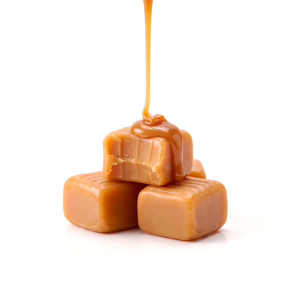 Fio de caramelo quente caindo sobre três caramelos de leite da Dolce Creatina, o de cima mordido, num fundo branco
